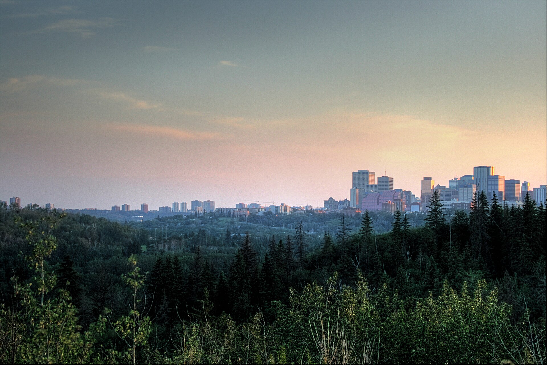 Downtown Edmonton at dusk above the forested North Saskatchewan River Valley
